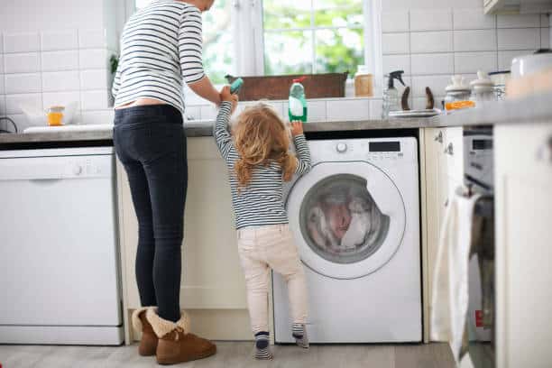 Jeune maman qui fait la vaisselle avec sa petite fille