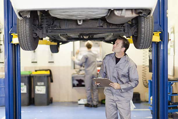 Garagiste en train d'effectuer le contrôle technique d'une voiture